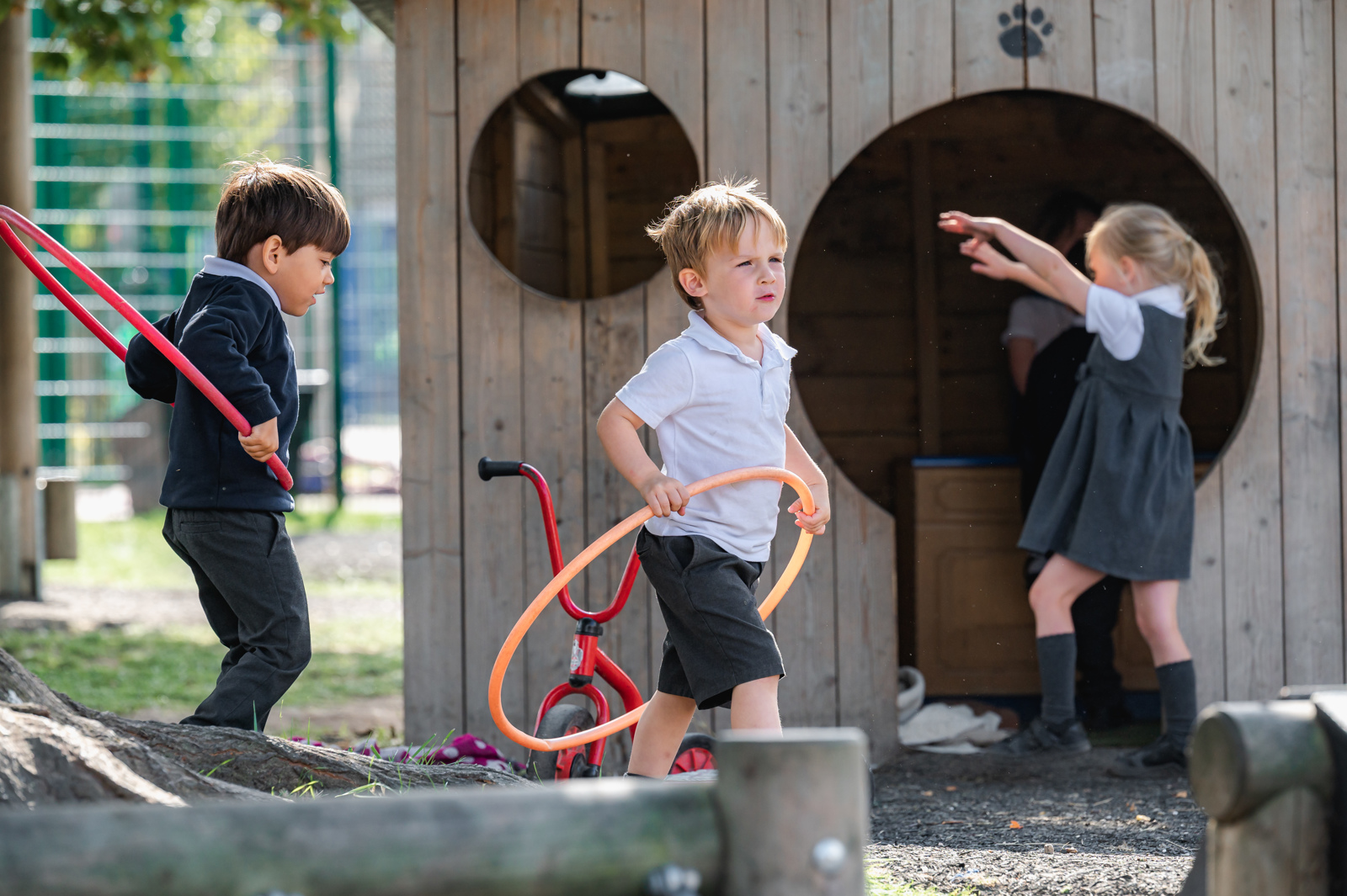 Children use hula hoops during play in the early years outdoor area
