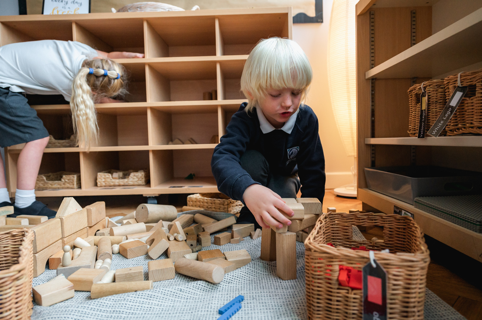 A boy uses wooden blocks to build